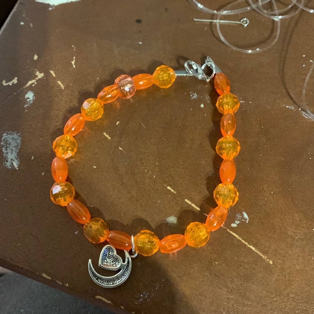 Orange anklet with a moonheart charm.